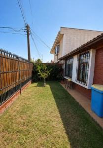 a yard in front of a house with a fence at Estrella rooms La Florida in Santiago