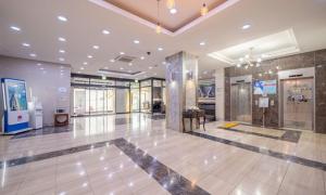 a lobby of a building with a large room with windows at Donghae Gloria Hotel in Donghae