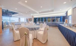 a banquet hall with white tables and white chairs at Donghae Gloria Hotel in Donghae