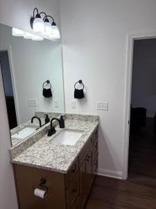 a bathroom with two sinks and a large mirror at Brand new condo right off the interstate in Berea +5 photos