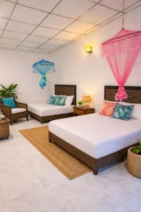 a bedroom with two beds and two chairs at Cottage Paramount in Udawalawe +33 photos
