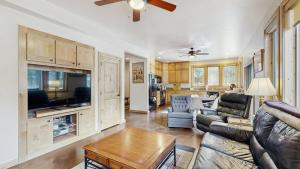a living room with a couch and a table at Rustic-Modern Cabin with Hot Tub Access in McCall