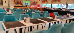 a conference room with tables and blue chairs at Le-Leisure Hotel in Prayagraj