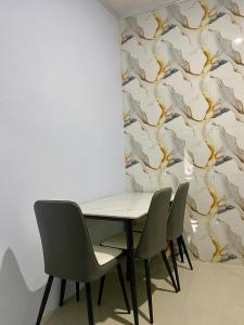 a table and chairs in a room with a wall at Sulis homestay in Kuta Lombok