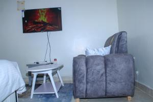a living room with a couch and a table and a television at Luxe Homes in Meru