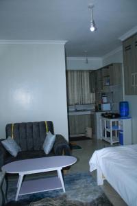 a living room with a couch and a table at Luxe Homes in Meru