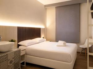 a hotel room with two beds and a sink at HOSTAL LETTO DAL MARE in Valencia