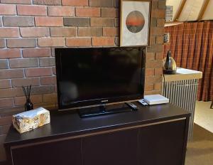 a flat screen tv sitting on top of a cabinet at Nikau Sanctuary in Raglan