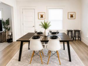 a dining room table with two white chairs and a table at Spacious Modern 2BR Apartment Sleeps 6 in Niagara Falls