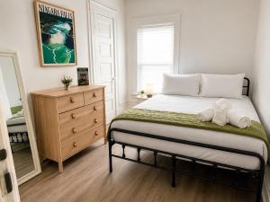 a bedroom with a bed with a dresser and a mirror at Spacious Modern 2BR Apartment Sleeps 6 in Niagara Falls