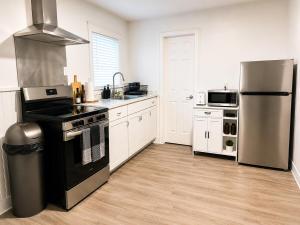 a kitchen with a stove and a refrigerator at Spacious Modern 2BR Apartment Sleeps 6 in Niagara Falls