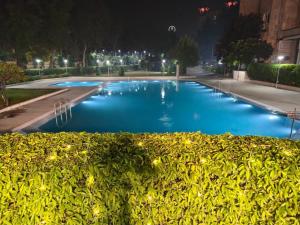a large blue swimming pool at night at Hotel Samrat, New Delhi in New Delhi