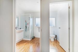 a white bathroom with a toilet and a sink at Williamson Getaway - Top Whangamata Location in Whangamata +18 photos