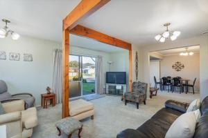 a living room with a couch and a tv at Williamson Getaway - Top Whangamata Location in Whangamata