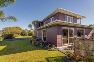 a pink house with a yard at Williamson Getaway - Top Whangamata Location in Whangamata