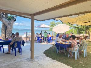 a group of people sitting at tables under an umbrella at Rimlay Bay View 2 in Ko Yao Noi