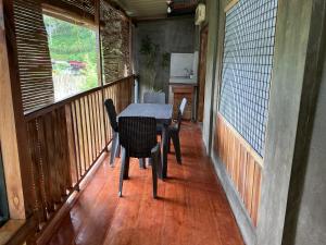 a porch with a table and chairs on a balcony at Cloudrest Marilog in Kayagan