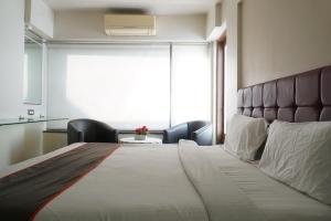 a bedroom with a large bed with a large window at S R Rooms in Pune