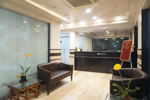 a lobby with two chairs and a table and a counter at S R Rooms in Pune