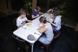 a group of people sitting at a table eating food at Cottage Paramount in Udawalawe