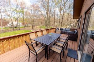 a wooden deck with a table and chairs at Pickleball Pool Table Hot Tub FirePit King Bed in Blakeslee