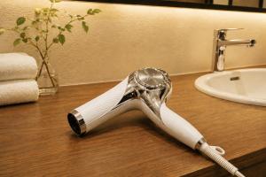 a shower head sitting on top of a bathroom counter at Axion Hotels Tenjin in Fukuoka