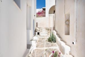 a narrow alley with flowers on the side of a building at Olga's House kythnos D in Kithnos