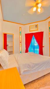 a bedroom with a white bed and red curtains at فندق مرتفعات القرم in Muscat