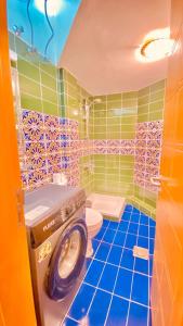 a bathroom with a toilet and a washing machine in it at فندق مرتفعات القرم in Muscat
