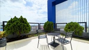 a table and chairs on a balcony with a view at OS Hotel Airport Batam in Batam Center