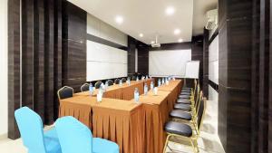a conference room with a long table and chairs at OS Hotel Airport Batam in Batam Center