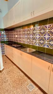 a kitchen with a sink and a tile wall at فندق مرتفعات القرم in Muscat +33 photos
