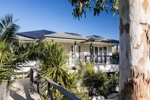 a white house with solar panels on the roof at Free night! Pay for 2 stay for 3 in Mollymook