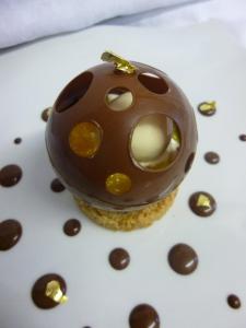 a chocolate covered cupcake on a white plate at Logis Auberge du Barrez in Mur-de-Barrez