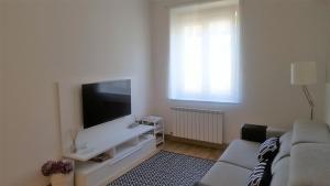 a living room with a couch and a flat screen tv at Concha Centro in San Sebastián