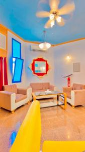 a living room with couches and a ceiling fan at Qurum Heights Hotel in Muscat