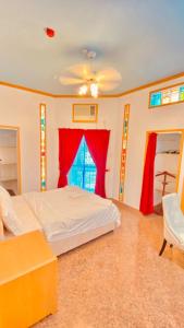 a bedroom with a bed and a red curtain at Qurum Heights Hotel in Muscat