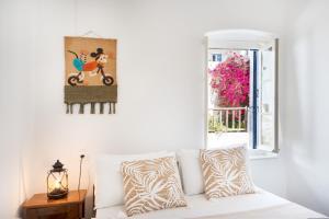 a white couch in a living room with a window at Olga's House Kythnos in Kithnos