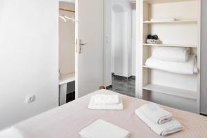 a white room with a table with towels on it at Olga's House Kythnos in Kithnos