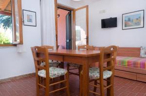 a wooden table with chairs and a bed in a room at Villa Maria Carla in Capoliveri