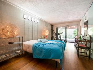 a bedroom with a bed with a blue blanket at Elegant villa with pool in Senigallia