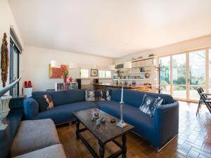 a living room with a blue couch and a table at Elegant villa with pool in Senigallia