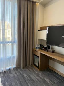 a hotel room with a television and a window at Metropol Hotel Bishkek in Bishkek