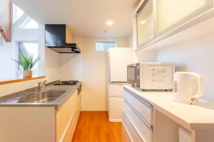 a kitchen with a sink and a microwave at 波の音テラス富津ー海眺望グッドデザイン受賞別荘を最大7名1棟貸切 in Futtsu