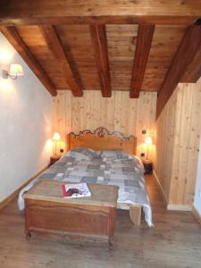 Schlafzimmer mit einem Bett mit Holzdecke in der Unterkunft Appartement Du Dou Des Ponts in Pralognan-la-Vanoise