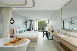 a bedroom with a bed and a tub in a room at AtEase Phuket Patong in Patong Beach