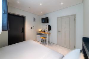 a bedroom with a bed and a desk and a mirror at BigBoxStay Myeongdong in Seoul