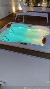 a jacuzzi tub with a chair in a room at Terra d'Acqua Resort & SPA in Torre Mozza +102 photos