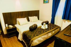 a bedroom with a bed with a stuffed animal on it at NAT CITY Hotel in Nuwara Eliya
