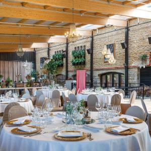 a banquet hall with white tables and chairs at Hotel Luze El Toro in Berrioplano